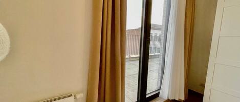 A room with a large sliding glass door leading to an outdoor balcony.