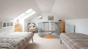 A bedroom with two beds, a skylight, a chair, a dresser, and a staircase. - 4guests-2br-privategarden-freeparking (Aviemore)