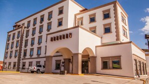 A multi-story hotel with a symmetrical facade, large windows, and a central entrance with arches. - HOTEL LA MINA PARRAL (Hidalgo del Parral)