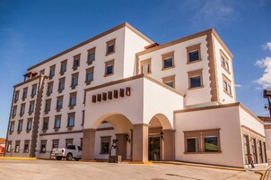 A multi-story hotel with a symmetrical facade, large windows, and a central entrance with arches.