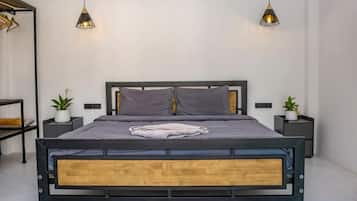 A modern bedroom with a wooden bed frame, two bedside tables, and hanging pendant lights.