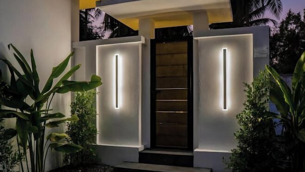 A modern house with a minimalist design, featuring a central wooden door flanked by two vertical light strips. - Ozzy Villa Phangan (Koh Phangan)