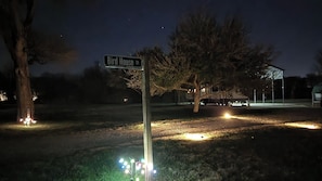 A street sign labeled 'Bird House Ct.' with a tree and a building in the background.