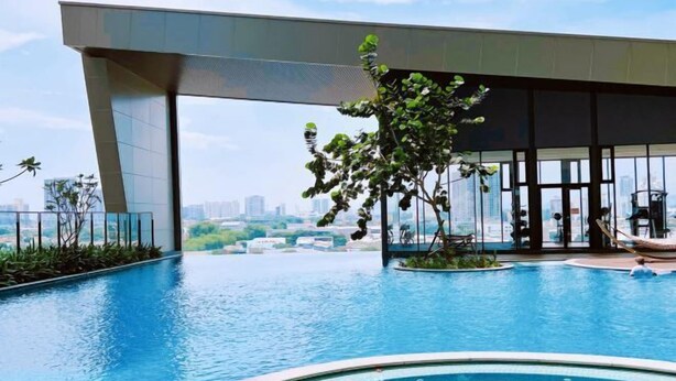 A modern indoor swimming pool with a view of the city skyline, surrounded by glass walls and a minimalist architectural design. - Kenwingston Skyloft Apartment Doorsteps to Brt Subang USJ (Subang Jaya)