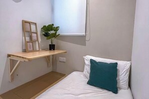 A small, neatly arranged bedroom with a bed, a shelf with a plant, and a window. - Kenwingston Skyloft Apartment Doorsteps to Brt Subang USJ (Subang Jaya)