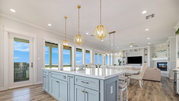 A spacious kitchen with a large island, pendant lighting, and a view to the outdoors. - Featured in American Dream Home !  Stunning Oceanfront Views for Days !! (Galveston)