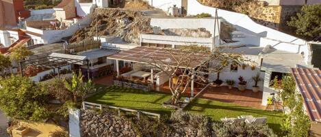 A residential property with a patio, a small garden, and a stone wall.