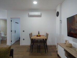 A dining area with a table, chairs, and a fruit bowl.