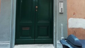A green double door with a small window above it, set within a stone archway. - Lovely and cosy apartment nearby Navona Square (Roma)