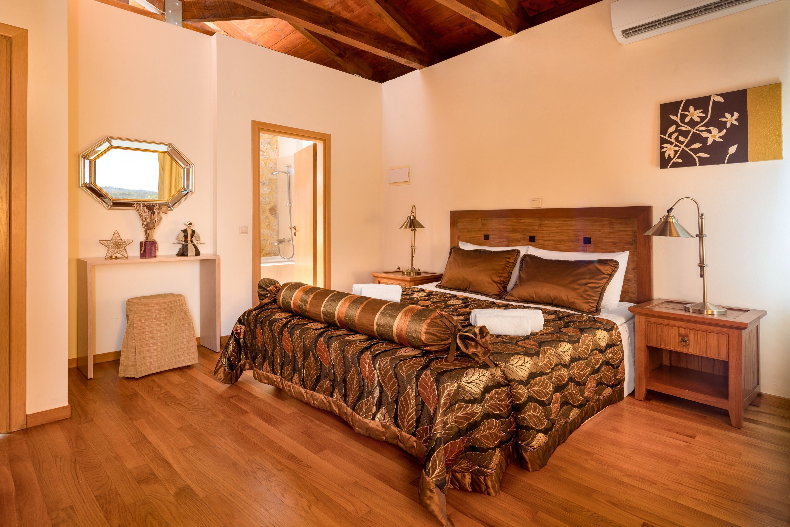 Una camera da letto con un letto di legno, un comodino, uno sgabello e uno specchio.