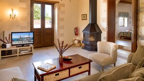 Una sala de estar acogedora con chimenea, televisión y asientos cómodos.