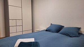 A bedroom with a bed, two pillows, a nightstand, and a wardrobe. - House Rustrel between Ochres and lavenders 3 bedrooms (Rustrel)