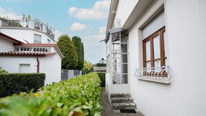 A narrow pathway flanked by white buildings with balconies, a metal railing, and a clear sky. - Villa Ada in Toscolano-maderno (Toscolano Maderno)