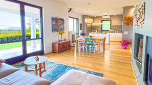 A spacious living room with a large window, a dining area, and a kitchen. - Villa Anna Miralago in Puegnago sul Garda (Puegnago del Garda)