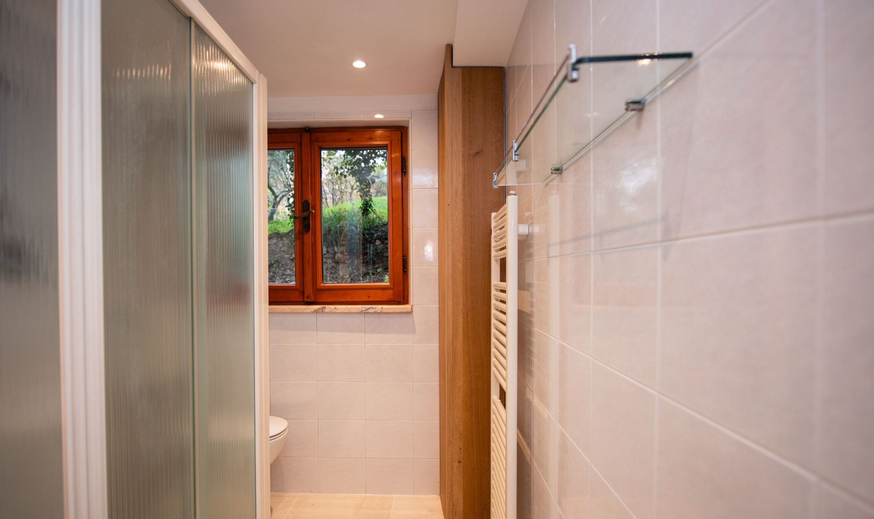 A modern bathroom with a toilet, a window, and a towel rack.