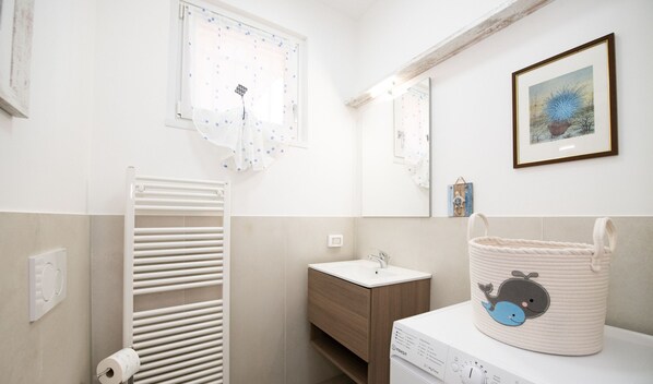 A bathroom with a white sink, wooden cabinet, and a towel rack. - Sweet Home Padenghe in Padenghe sul Garda (Padenghe sul Garda)