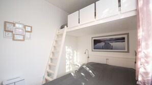 A bedroom with a bunk bed, a ladder, a framed picture, and a bedside table. - Villaggio Tavaredo - App 02 (Polpenazze del Garda)