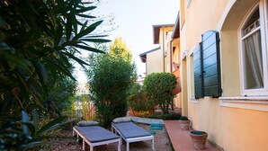 A garden with two lounge chairs and potted plants. - Borgo del Torchio - App H5 (Manerba del Garda)