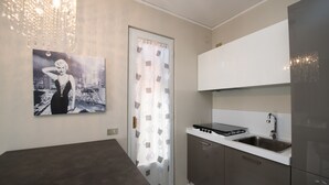 Una cocina moderna con estufa integrada, un fregadero y un amplio ventanal con cortina.