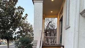 A concrete staircase leading to a building entrance with a white railing and a small porch area. - Spacious Waterfront Home for Groups (Stockton)