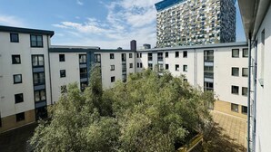 Un edificio residencial de varios pisos con un diseño arquitectónico moderno, que presenta una combinación de balcones y ventanas.