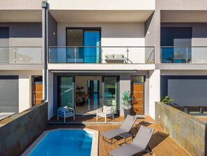 A modern two-story building with a rooftop pool, outdoor seating, and a covered patio area. - Villa Alegre With Private Pool (Albufeira)