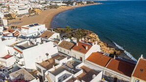 A coastal town with white buildings, a beach, and the sea.