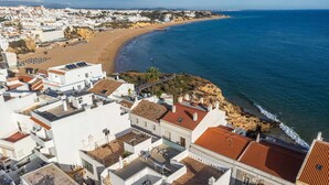A coastal town with white buildings, a beach, and the sea.