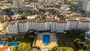 A large hotel with multiple buildings, a central swimming pool, and a view of the sea. - Montechoro Sea View 3 Bedroom Apartment (Albufeira)