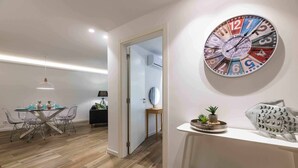 Ein modernes Wohnzimmer mit Essbereich, einer Wanduhr und einer Fischskulptur.