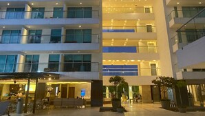 A multi-story hotel with a central atrium, balconies, and a ground-level restaurant area.