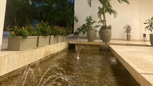 A modern building with a water feature in the courtyard.