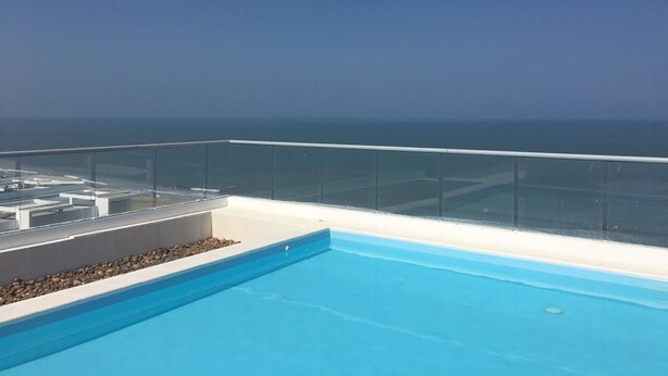 A rooftop pool with a clear view of the ocean.