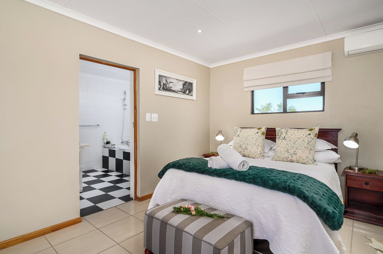 A bedroom with a bed, bedside tables, a window, and a door leading to a bathroom.