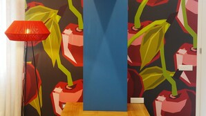 Un interno moderno con un murale vivace, una panca di legno e una lampada da terra rossa.