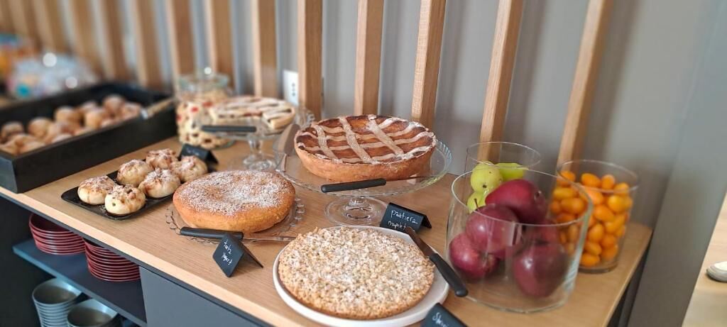 A buffet table with various baked goods and fresh fruits.