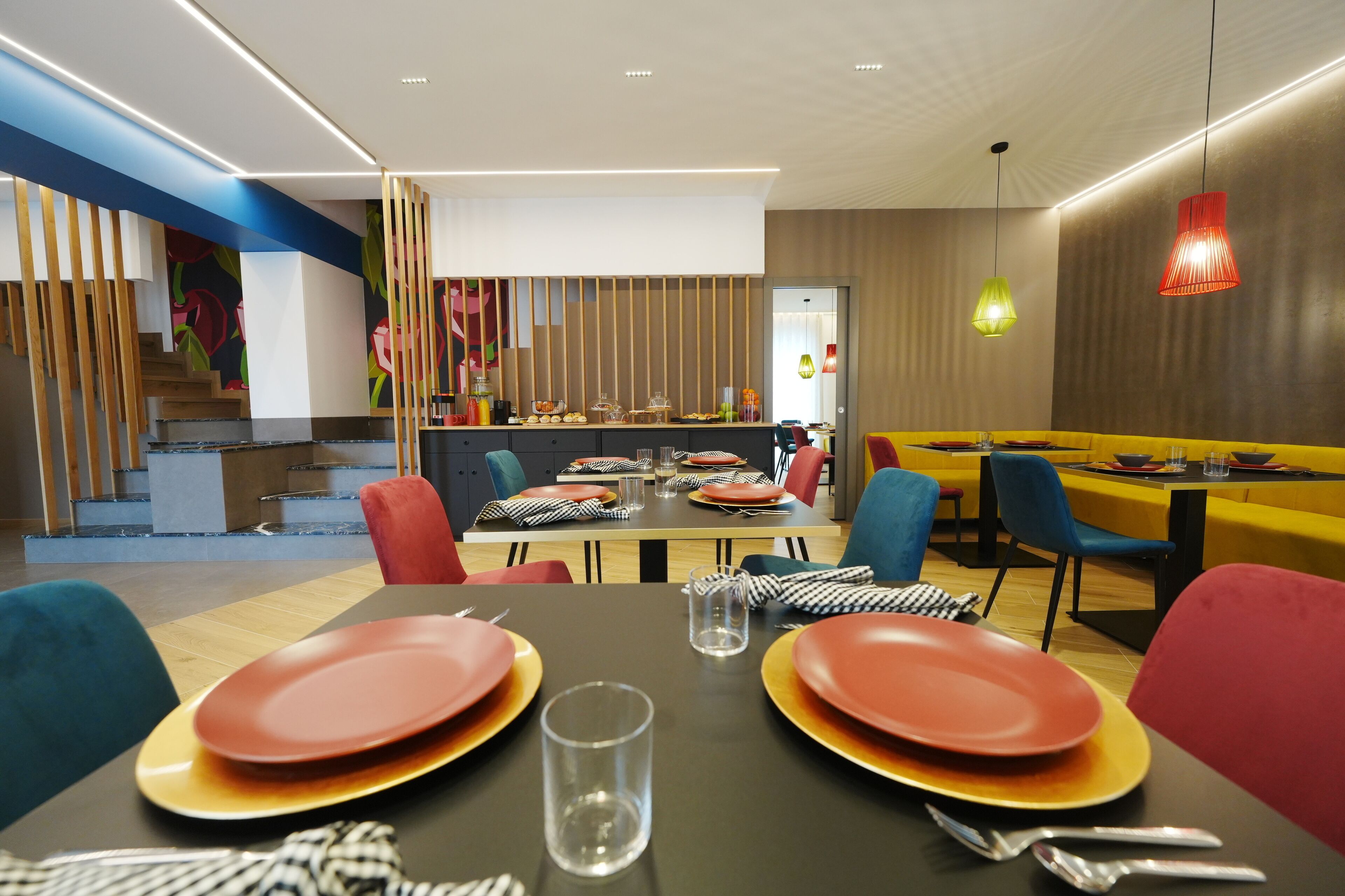Ein moderner Essbereich mit Treppe, einem Buffet und einer Mischung aus bunten Stühlen und Tischen.