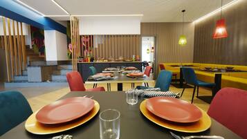 A modern dining area with a staircase, a buffet, and a mix of colorful chairs and tables.