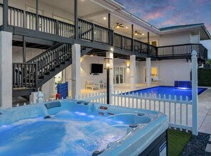 Une maison moderne dotée d’un jacuzzi, d’une piscine et d’un espace extérieur couvert avec un escalier.