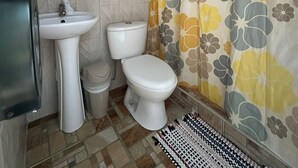 Un baño con lavabo, inodoro y cortina de ducha.
