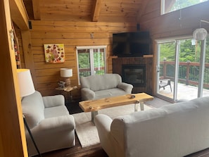 A cozy cabin interior with a sofa, armchair, and a wooden coffee table.