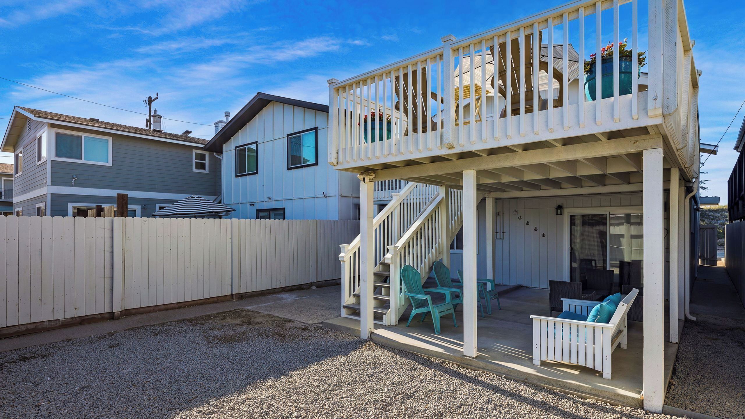 A two-story house with a covered porch and outdoor seating.