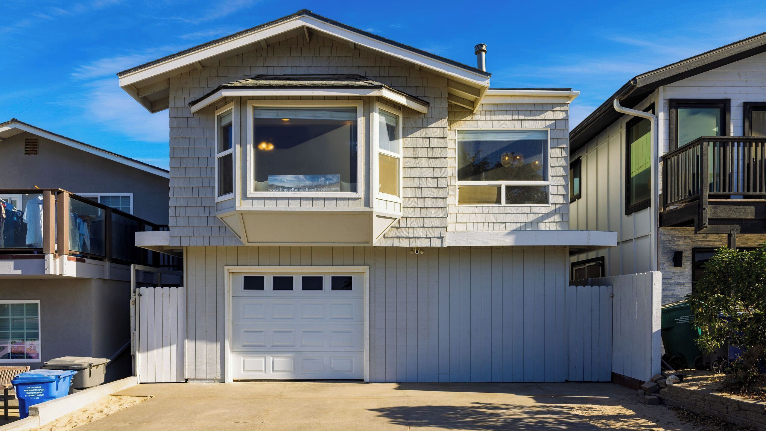 Ein zweistöckiges Haus mit Garage, Erker und Balkon.