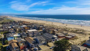 Uma área residencial costeira com casas, praia e o oceano.