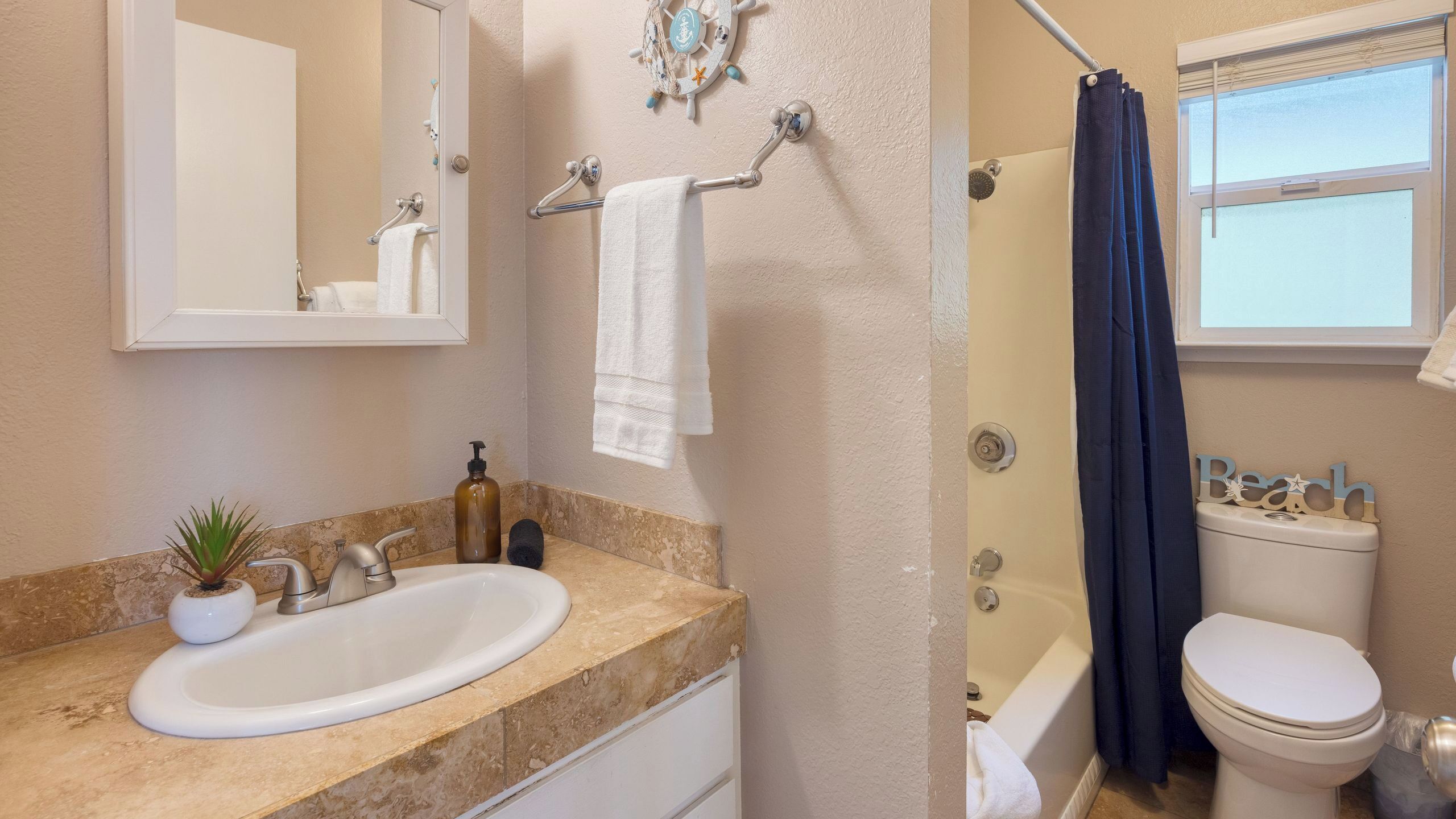 A bathroom with a sink, mirror, towel rack, toilet, and bathtub.