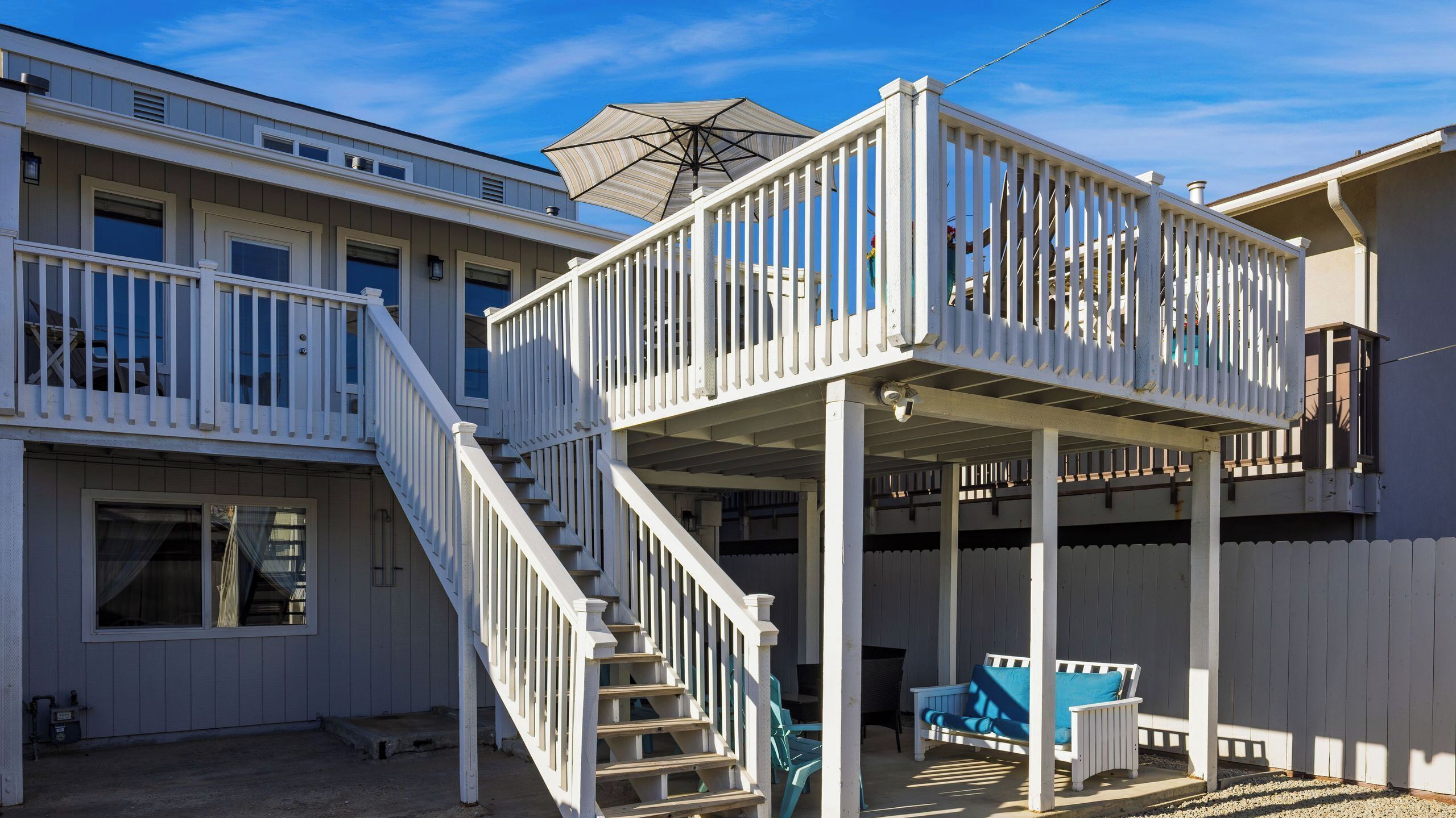 A two-story house with a balcony and a covered patio area.