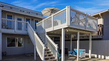 A two-story house with a balcony and a covered patio area.