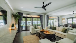 A spacious living room with a large sofa set, a coffee table, and a ceiling fan. - Eden Villa A Tropical Paradise Pool Villa (Phuket)