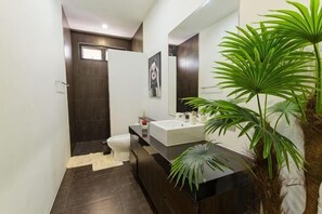 Een moderne badkamer met een grote spiegel, een wastafel en een toilet.