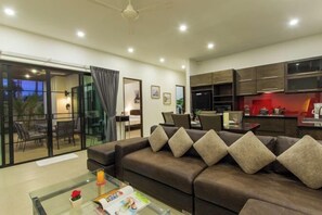 Relax in this stylish living room with a sofa, coffee table, and glass door leading to an outdoor area.